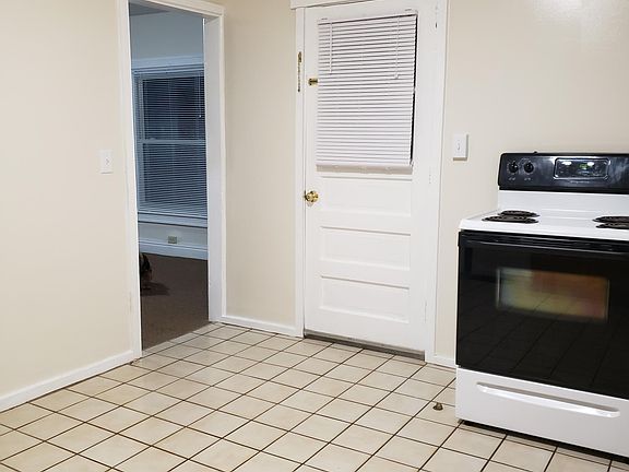 Kitchen has a door that leads onto a back porch.