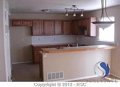 kitchen w/ tile, refrigerator is there