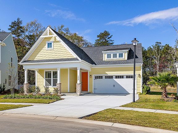 A yellow house with a white garage door is sitting next to a blue house.