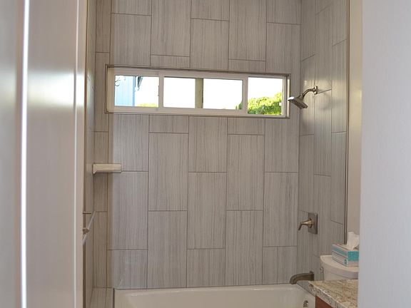 2nd bathroom with tiled floors and shower area.
