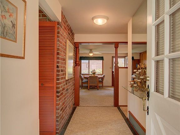 Entry hall has slate tile under the carpet runner.