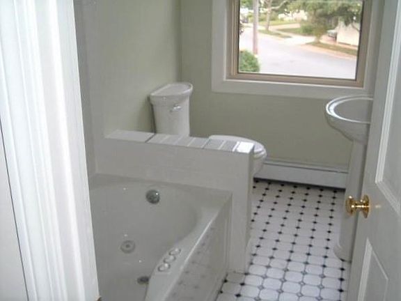 Renovated bathroom with jacuzzi tub, tile floor.