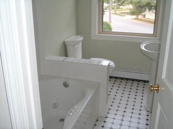 Renovated bathroom with jacuzzi tub, tile floor.