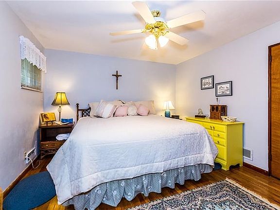 Spacious master bedroom has a full wall of closet space and exposed hard wood floor.