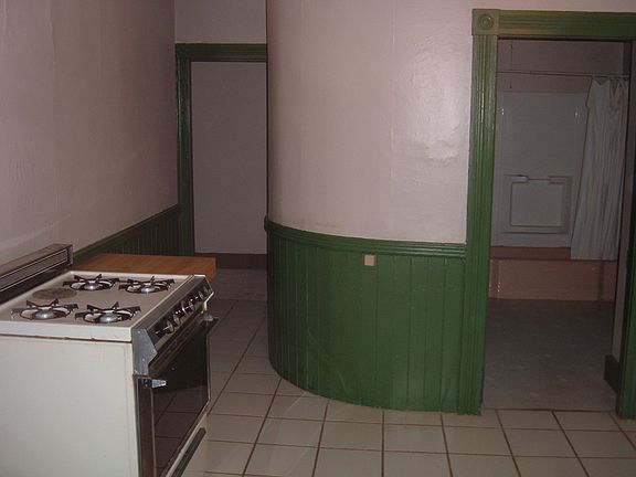Rounded wall curves twards hallway and basement door