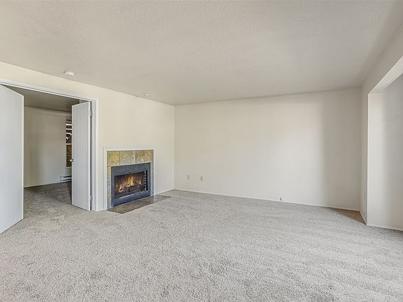 Spacious living room offers the perfect ambiance with the natural light and the cozy fireplace.>