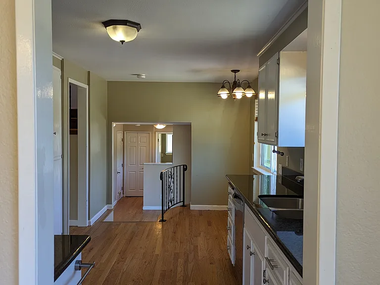 View into kitchen from dining room; which leads to breakfast nook and family room