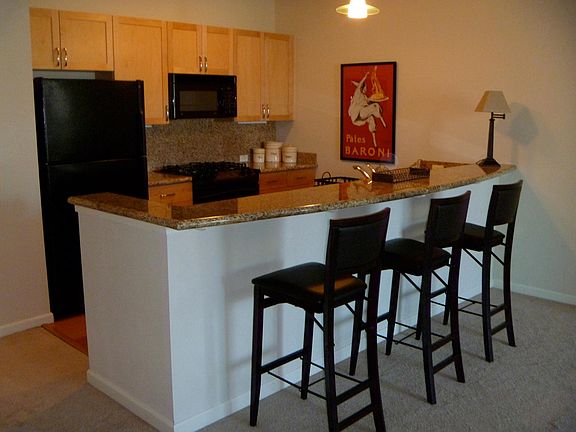 Pine cabinets, black appliances , large granite bar perfect for entertaining or workspace for your laptop. There are also 4 stools /chairs at the counter