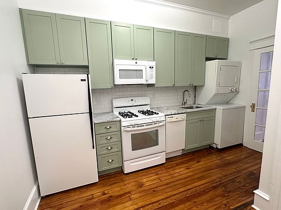 Eat-in kitchen with quartzite countertop, dishwasher, microwave, garbage disposal, and washer & dryer.