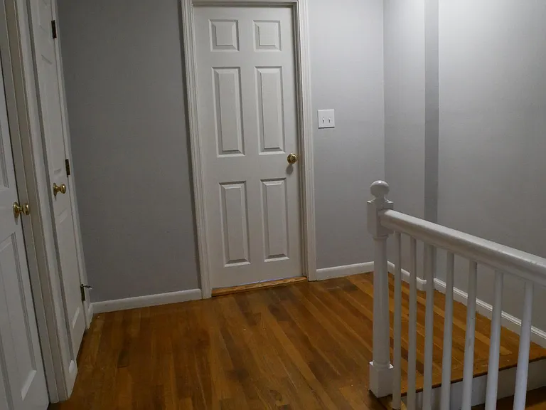 Landing at top of stairs, full bath door in middle, linen closet on left.