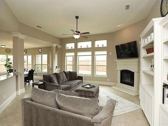 This view of the family room also shows the Sun Room Breakfast Area. Very Open Concept! Wall Unit is an Exclusion. TVs are also 