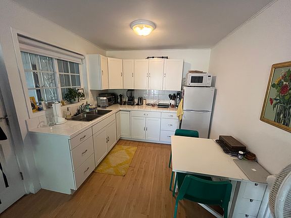 Kitchen with full size, thin fridge. Room for small table. Window above full size sink. Microwave, double hot plate, toaster oven provided.