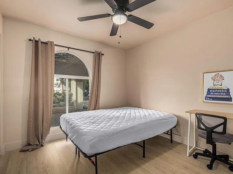 Actual bedroom: queen bed, desk, chair, lamp, fan, closet.