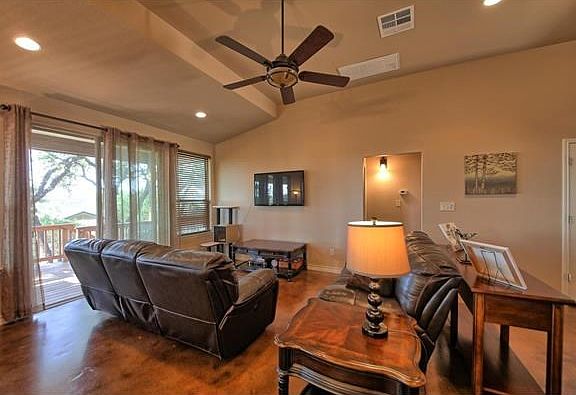 Stained concrete floors are a feature of this delightful home, here seen in the main living area, which leads to covered balcony beyond