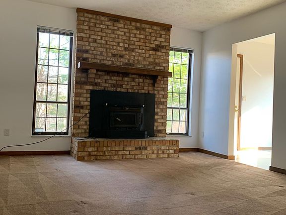 Cozy den off the kitchen with floor to ceiling brick fireplace