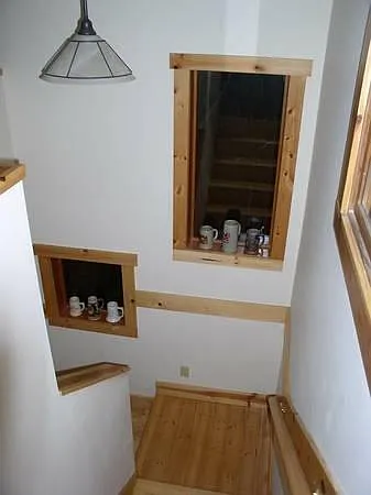 Attractive stairs leading to daylight basement. under the landing is an inside dog house with doggie door.
