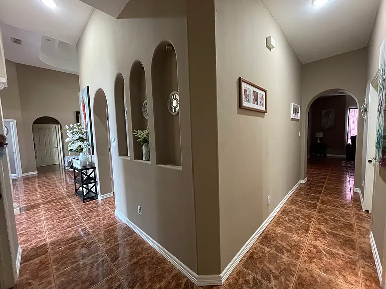 Hallway divider leading from the front flex space toward the main living area and kitchen. Two bedrooms and a full bathroom are conveniently located off this hallway _ ideal for guests or family members.