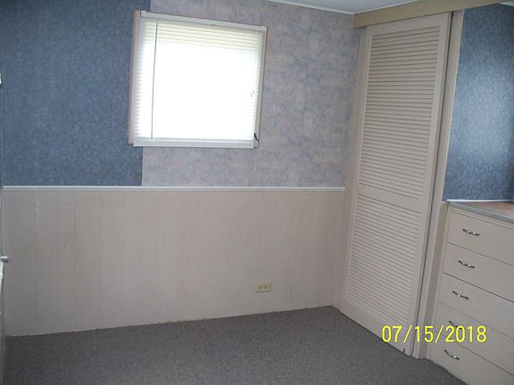 Bedroom, window on North, East, and West. Matching closet on each side of built in drawers.