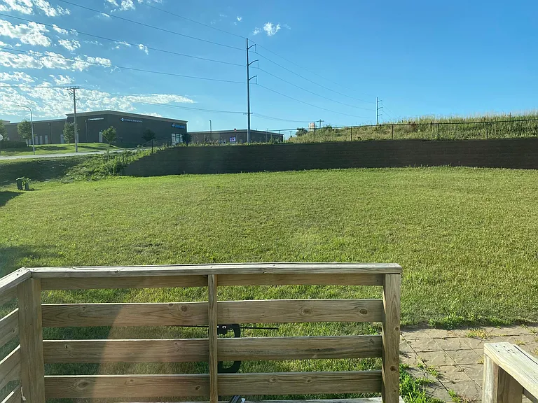 partially fenced back yard with deck and paver patio