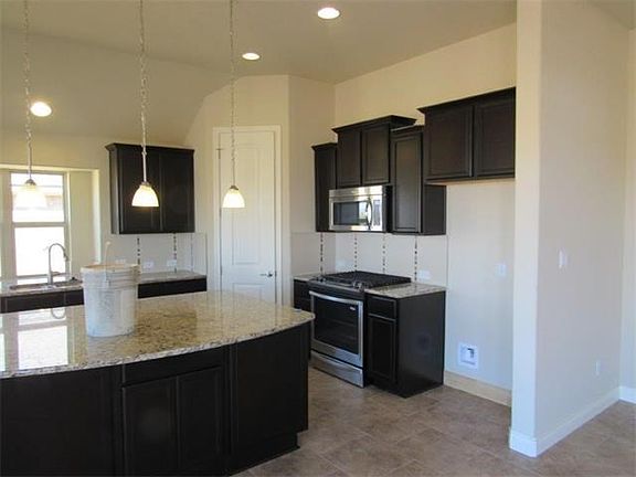 Large kitchen with dark cabinetry and spacious island.