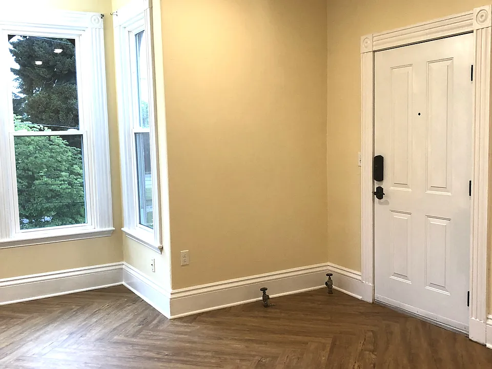This is standing in the middle of the room. Looking towards the front door and bay window. The kitchen is behind me. The floors are luxury vinyl plank. I love the herringbone pattern but very practical.