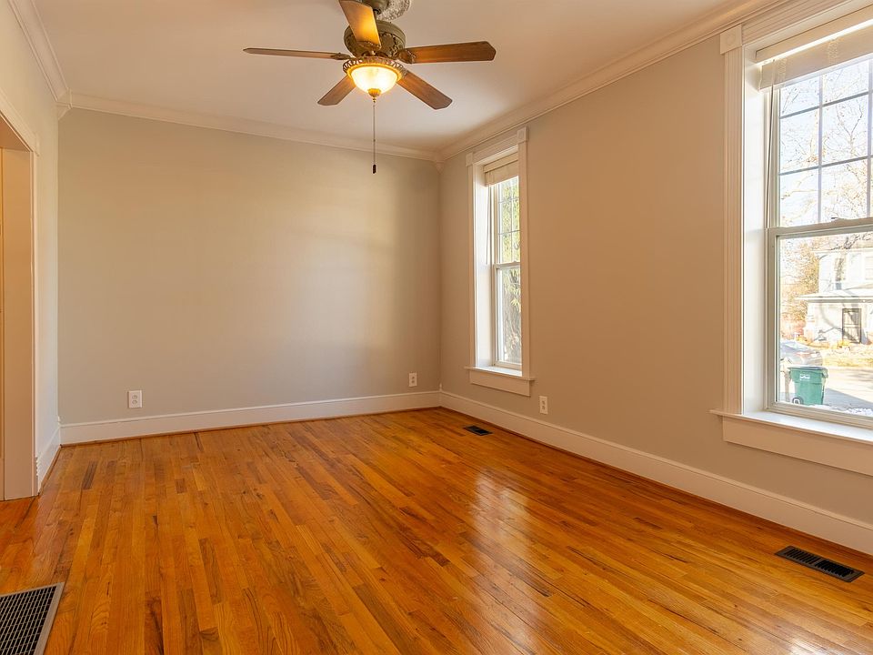 Front living area features high ceilings, oversized windows, hardwood oak flooring and crown molding