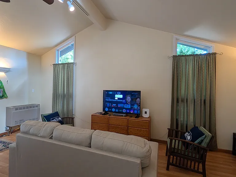 Living room with vaulted ceilings and couch that pulls out to a Queen and Wifi included!