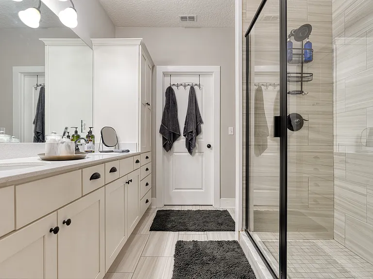 Unpack and feel at home. Our master bathroom features extensive built-in linen cabinetry, dual vanities, and a beautifully tiled step-in shower equipped with premium showerheads.