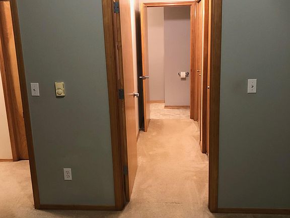 hallway leading to bathroom with 2 closets