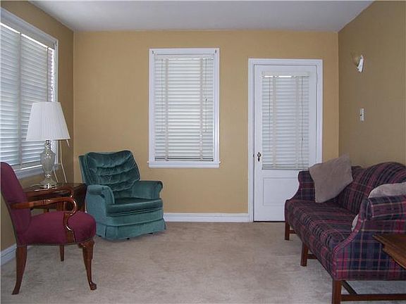 The living room has carpet over the hardwood floor