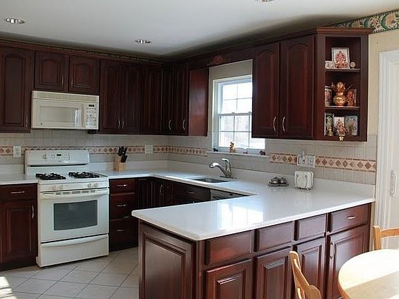 Cherry kitchen cabinets with appliances and Silestone countertop