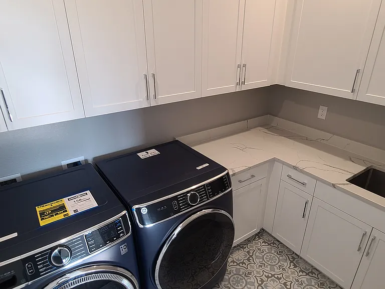 Laundry room with plenty of cabinets, counter space, and sink.