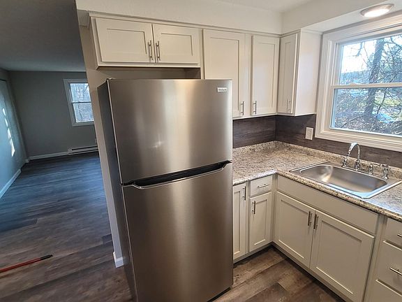 KITCHEN - ALL NEW WITH SOLID WOOD CABINETS, WOOD BACKSPLASH, STAINLESS STEEL FRIDGE, RANGE, AND DISHWASHER, LED LIGHTING THROUGHOUT HOME