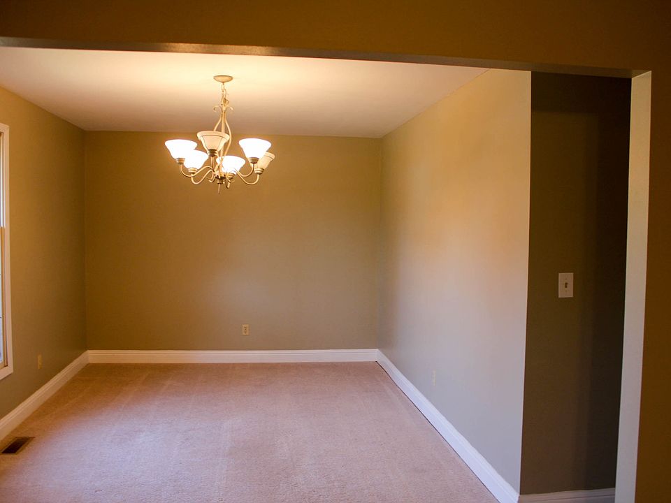 living room leading into dining room with hall way to the ki