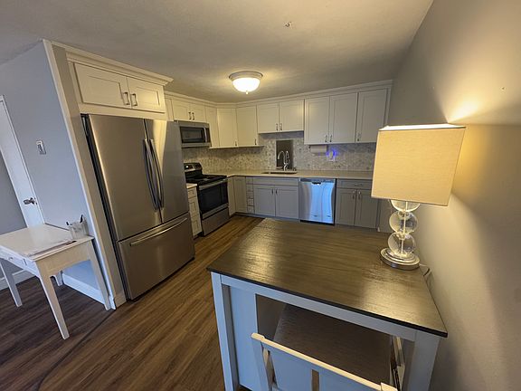 Open kitchen, new refrigerator and new cabinets, sink, tile, recently added vinyl flooring last year.