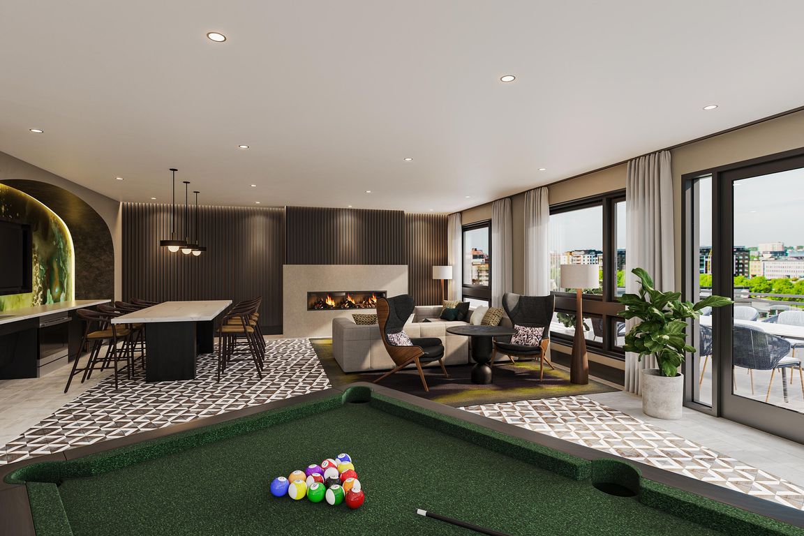 Rooftop lounge with billiards, fireplace, and outdoor terrace with sweeping views towards the Capitol.