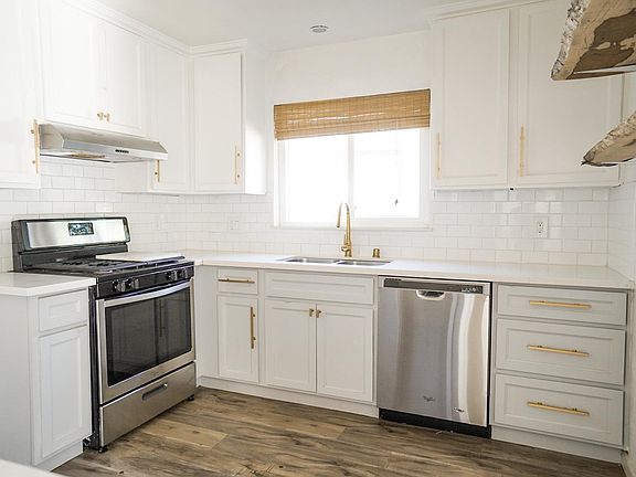 Kitchen with ss appliances , microwave and undercounted refrigerator under kitchen Island on opposite side
