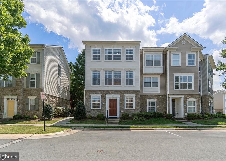 Beautiful rock front with burgundy door and lots of windows; front visitor parking spaces