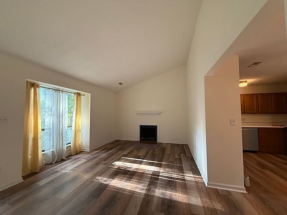 The floor plan is open, but the kitchen work area is not in the living room. The dining area is open to the living room and also has a slider to the deck.