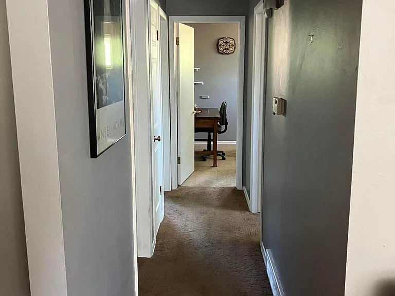 Main level hallway - view into bathroom (on left) and 3 bedroom doorways
