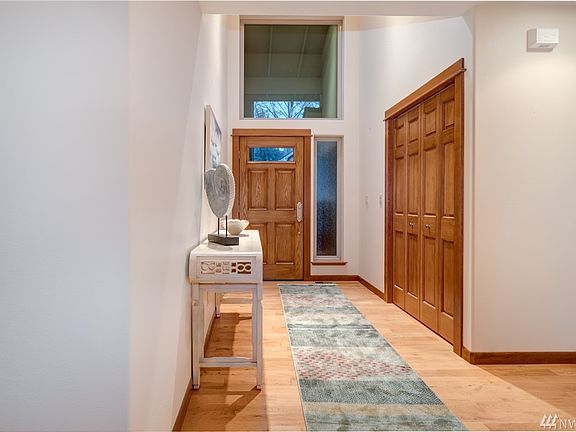 The beautiful hardwood floors begin at the entryway, which features a vaulted ceiling and large transom window.  