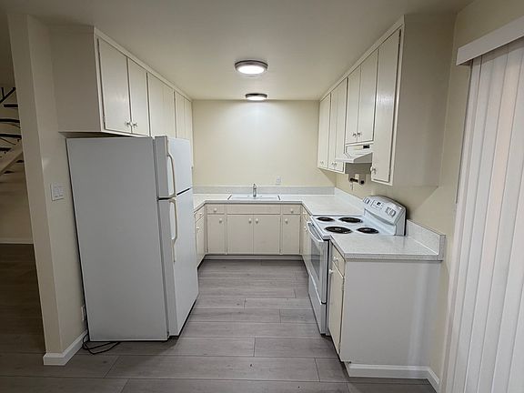 Kitchen area: Oven, refrigerator, cabinet storage