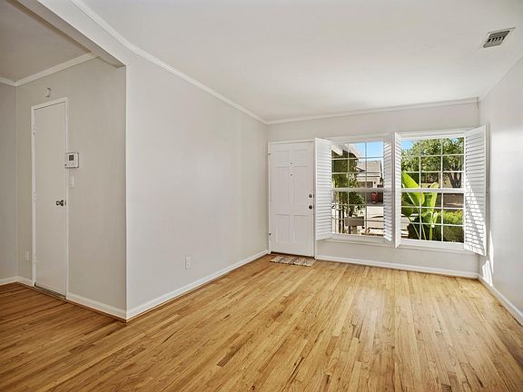 Living room. Wood floors, lots of light. Door into garage at left.