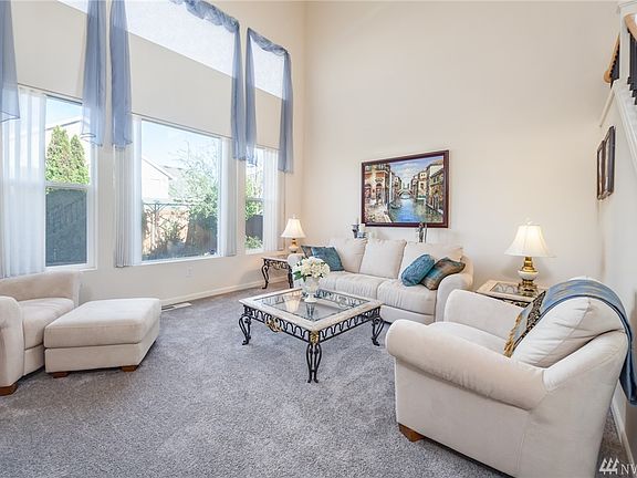 Formal living room with large picture windows and vaulted ceiling