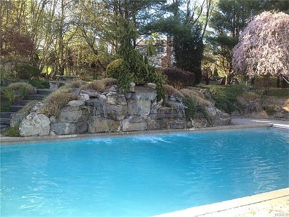 Waterfall over custom stone work cascades into the pool.