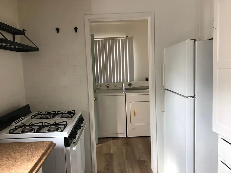 Looking through kitchen to the laundry room and front door to unit.