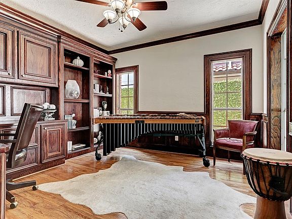 Hardwood floors and stained wood cabinetry and wainscoting, the study is ideally situated just off of the foyer.