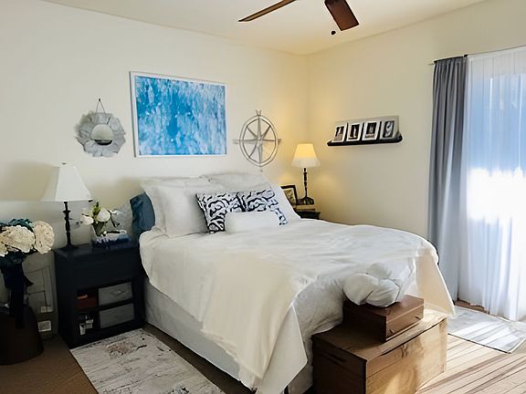 Bedroom with walk in closet and sliding door to balcony overlooking gardens