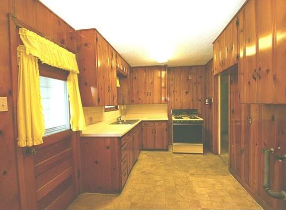 Kitchen has lots of knotty pine cabinetry and paneling. the metal pipe in the right of the picture is the hook up for the washing machine:)