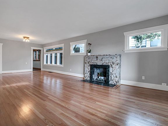 Living room with period details including original leaded window in dining room and fireplace in living room.